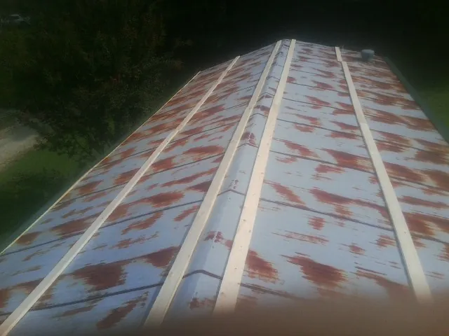 Rusted metal roof panels with new wood purlins before replacement — Storm Damage Roof Repair in Astatula by Roofing Brothers